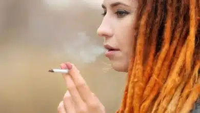צעירה עם ראסטות מעשנת ג'וינט קנאביס