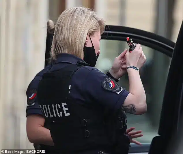 שוטרת בוחנת את מכשיר האידוי (תמונה: הדיילי מייל)